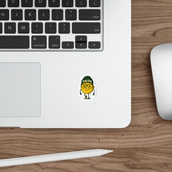 Laptop with a sticker on a wooden desk, featuring a character wearing glasses and a 'Faith' hat.