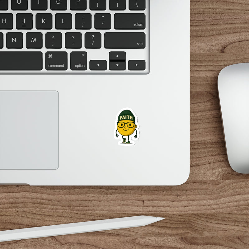 Laptop with a sticker on a wooden desk, featuring a character wearing glasses and a 'Faith' hat.