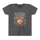 Retro-style t-shirt with “Be Kind to Your Mind” text, featuring a smiling cartoon brain hugging a heart, surrounded by peaceful doodles and affirmations like “Breathe,” “Grow,” and “Rest.”