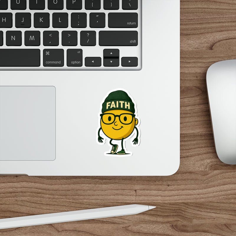 Laptop with a sticker of a yellow character wearing a green hat with 'FAITH' on it, on a wooden desk.