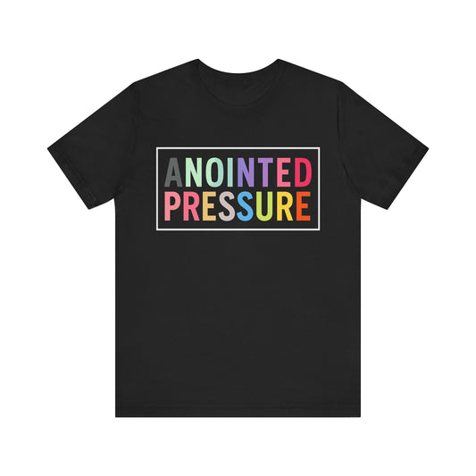 “Anointed Pressure” in bold pastel-colored letters, framed in white on a black background, representing strength and purpose through faith.

