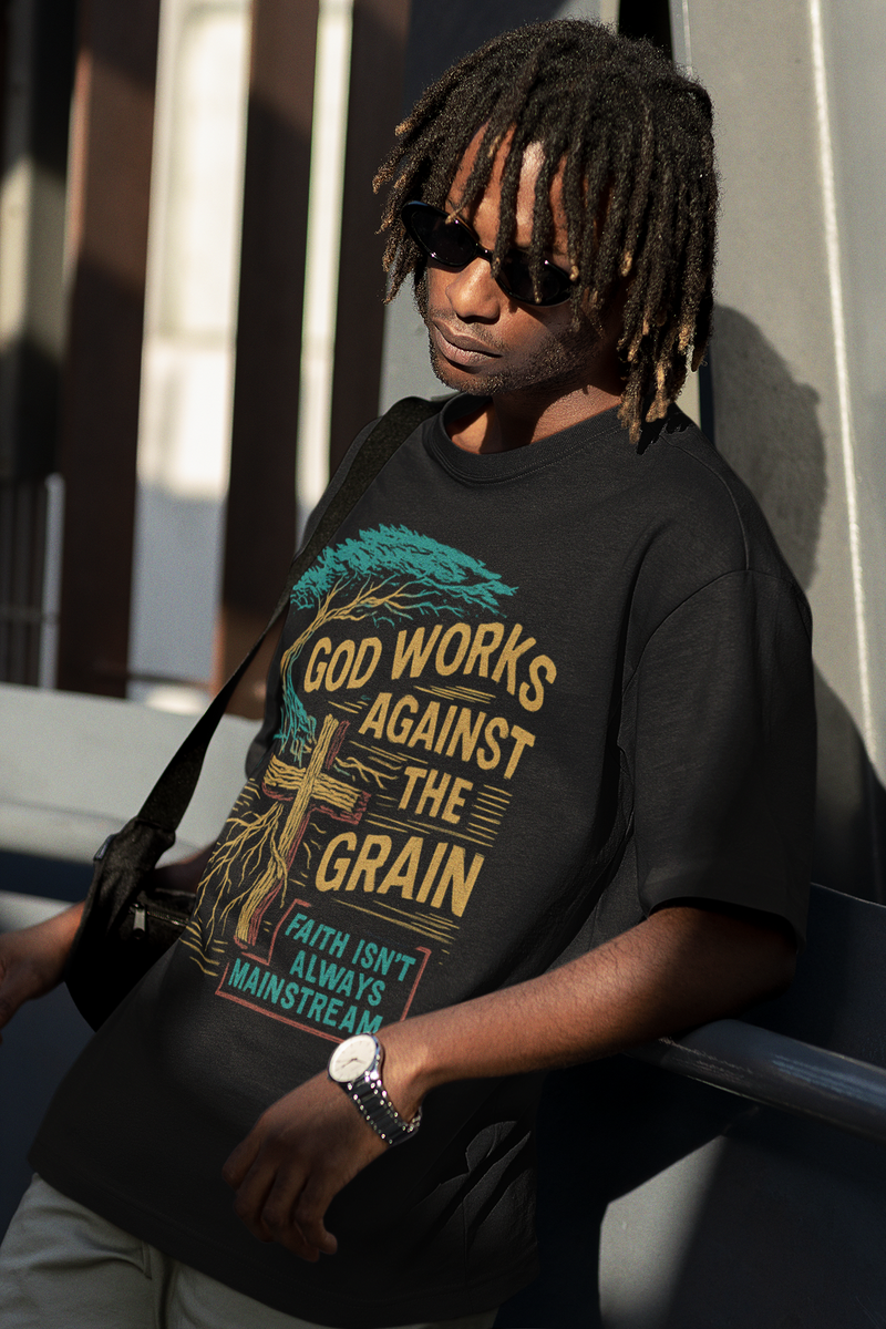 "Model wearing God Works Against the Grain Christian t-shirt in black, faith-based streetwear style by Klippette."
