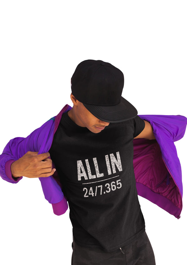 Person wearing a black t-shirt with 'ALL IN 24/7.365' text, holding a purple jacket.