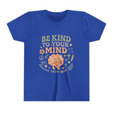 Retro-style t-shirt with “Be Kind to Your Mind” text, featuring a smiling cartoon brain hugging a heart, surrounded by peaceful doodles and affirmations like “Breathe,” “Grow,” and “Rest.”