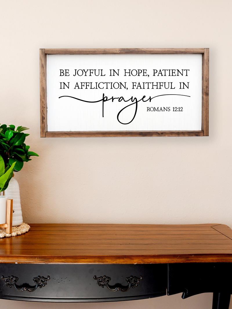 Decorative wall sign with inspirational quote above a wooden table.